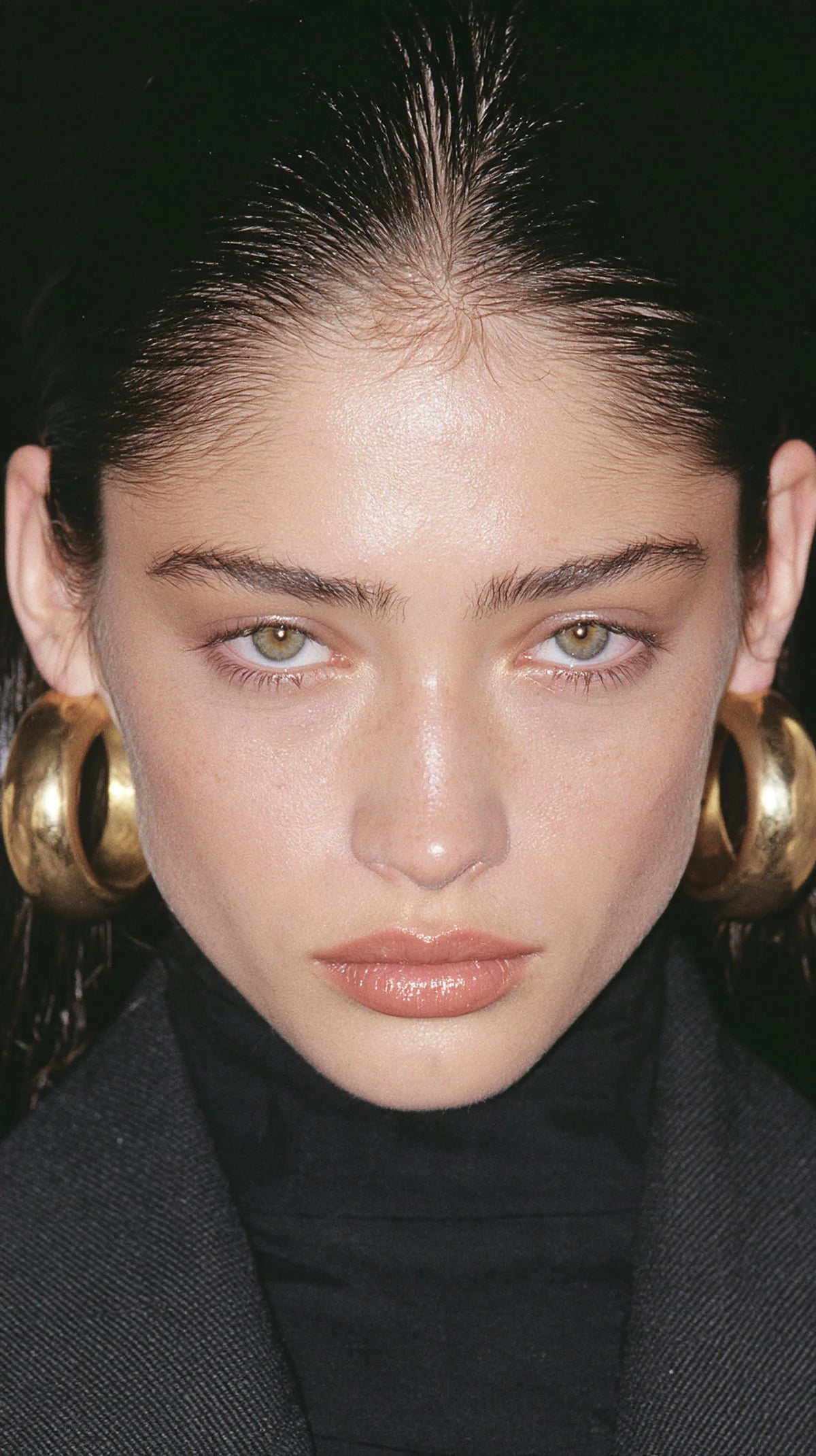 Editorial portrait, sleek hair and gold hoop earrings